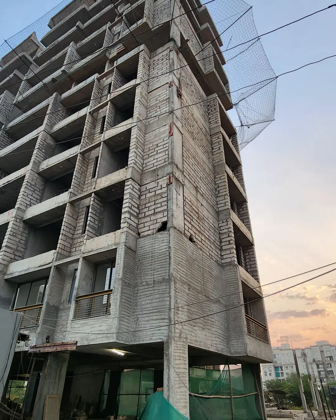 Low-angle view of a multi-storey commercial building with glazing work in progress